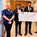 Paul Sharma presents the cheque for £1,500 to Ward 14 at PCH.