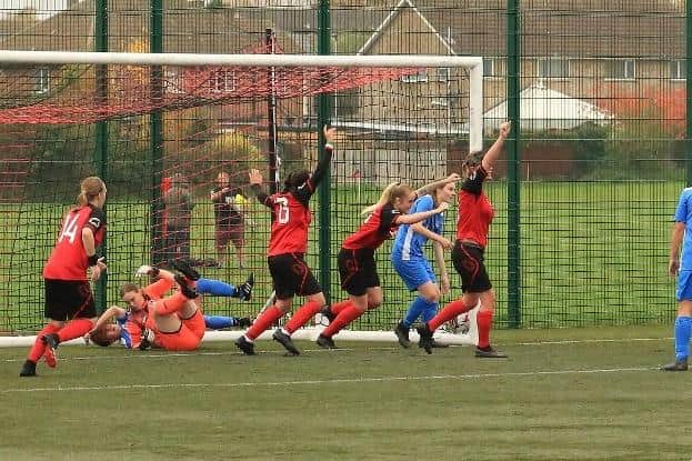 Ellie Hannan (red shirt, blonde hair) has just scored for Netherton against Knowle.  Photo: Roger Ellison.
