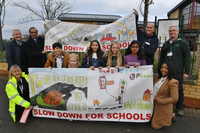 The new road safety posters outside Hampton Hargate primary school with the pupils who did the artwork, local councillors and council officials. EMN-211119-144356009