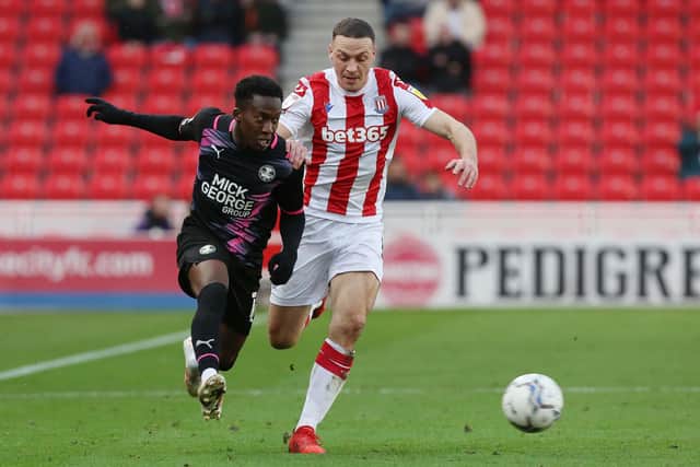 Siriki Dembele of Peterborough United in action with James Chester of Stoke City. Photo: Joe Dent/theposh.com