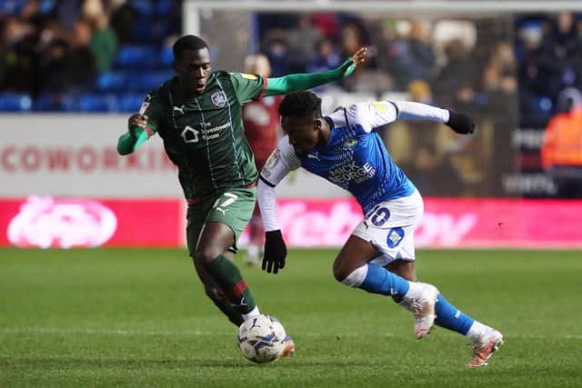 Siriki Dembele of Peterborough United in action with Claudio Gomes of Barnsley.