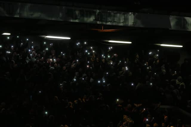 Fans in the stands use their phone torches after the floodlights go out midway through the second half in the game between Posh and Barnsley. Photo: Joe Dent/theposh.com