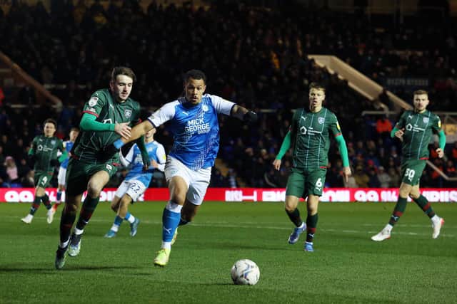 Jonson Clarke-Harris of Peterborough United in action with Liam Kitching of Barnsley. Photo: Joe Dent/theposh.com.