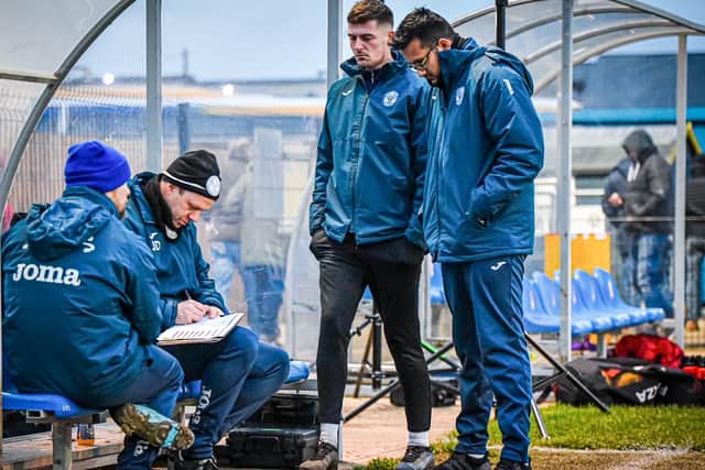 Peterborough Sports manager Jimmy Dean (seated) and his management team during the game against Redditch. Photo: James Richardson.