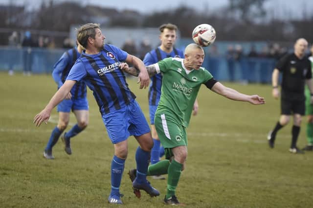 Whittlesey player/manager Ricky Hailstone (blue) in action against Newport Pagnell.  Photo: David Lowndes.