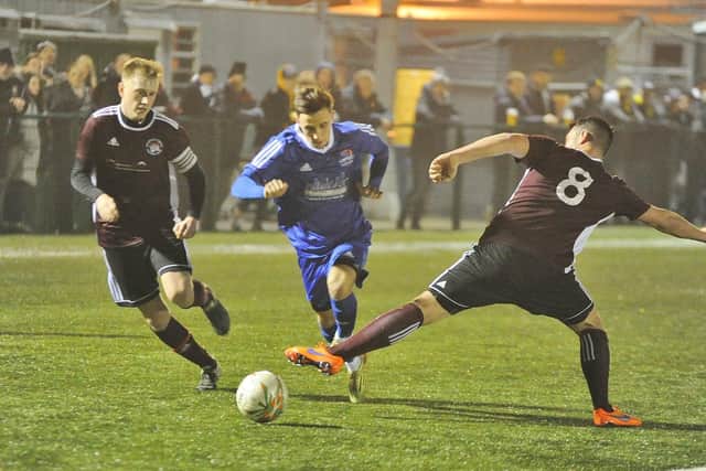 Matt Sparrow (blue) scored for Yaxley at Spalding.