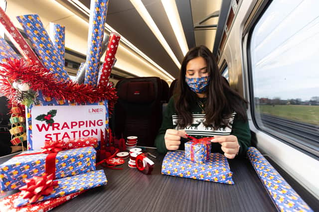 Professional gift wrapper Finn Drumgoole wraps presents for LNER customers to launch the rail operator's complimentary 'Rail Wrapping' service. Pic:David Parry/PA Wire EMN-211214-110142005