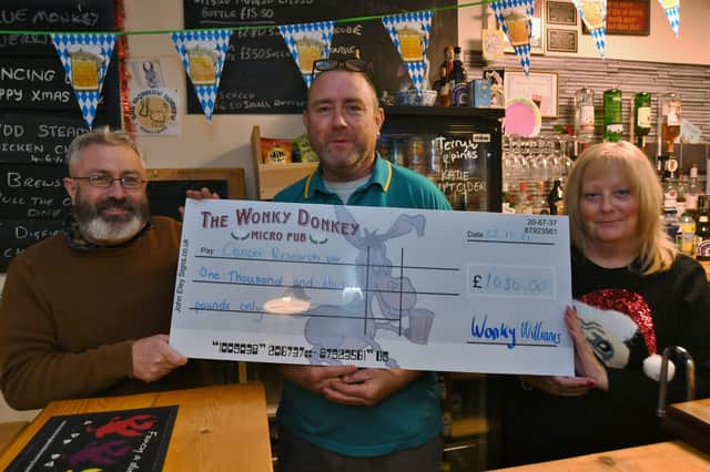 Gaynor Jackson from Cancer Research receives a cheque from Dave and  Andy Williams from the Wonky Donkey EMN-211222-170317009