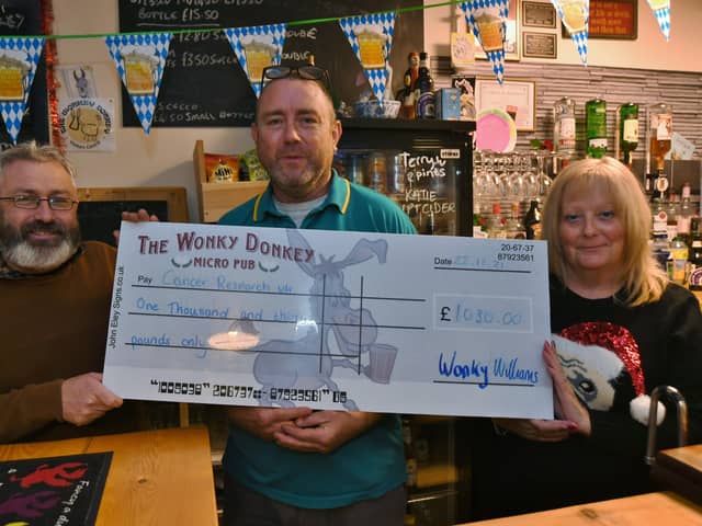 Gaynor Jackson from Cancer Research receives a cheque from Dave and  Andy Williams from the Wonky Donkey EMN-211222-170317009