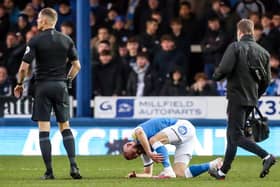 Dan Butler is injured early in the Posh game against Millwall.