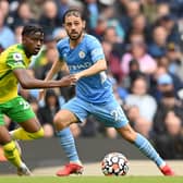 Bali Mumba (yellow) in action for Norwich City at Manchester City in a Premier League game earlier this season. Bernando Silva is the City player. Photo: Michael Regan (Getty Images).