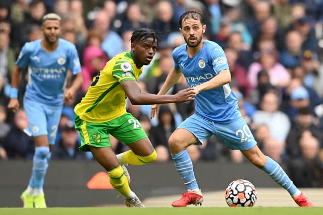 Bali Mumba (yellow) in action for Norwich City at Manchester City in a Premier League game earlier this season. Bernando Silva is the City player. Photo: Michael Regan (Getty Images).
