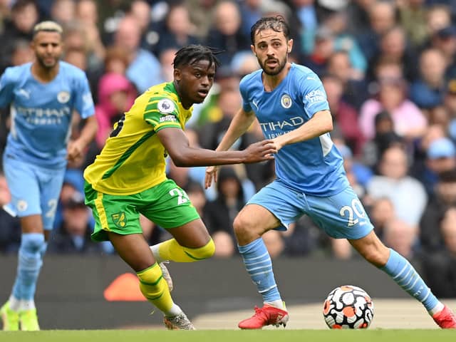 Bali Mumba (yellow) in action for Norwich City at Manchester City in a Premier League game earlier this season. Bernando Silva is the City player. Photo: Michael Regan (Getty Images).