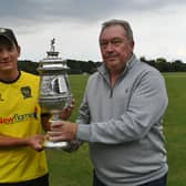 Peterborough Town skipper David Clarke receives the 2021 Northants Premier Division trophy.