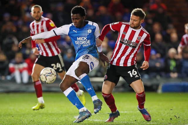Kwame Poku of Peterborough United in action with Oliver Norwood of Sheffield United. Photo: Joe Dent/theposh.com.