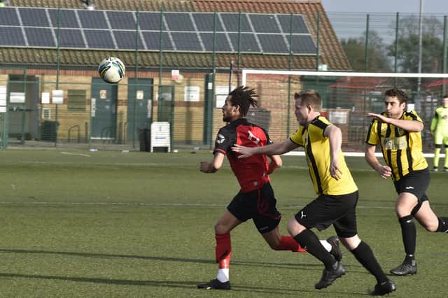 Hat-trick hero Kieran Duffy-Weekes (red) in action for Netherton United against Crowland in the Peterborough Senior Cup. Photo: David Lowndes.