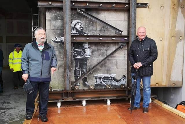 Art dealer John Brandler (left), with garage owner Ian Lewis, with Banksy's Season's Greetings prior to its removal to an art gallery pa-new/ARTS Banksy  19040726.JPG