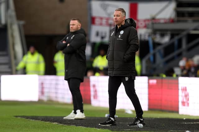 Peterborough United Manager Darren Ferguson watches on from the touchline alongside Derby County manager Wayne Rooney. Photo: Joe Dent/theposh.com.