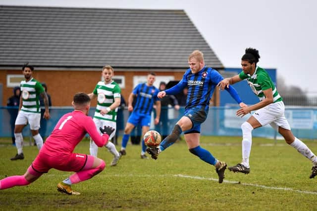 Jack Carter (blue) of Whittlesey Athletic closes in on the Framlingham goal. Photo: James Richardson.