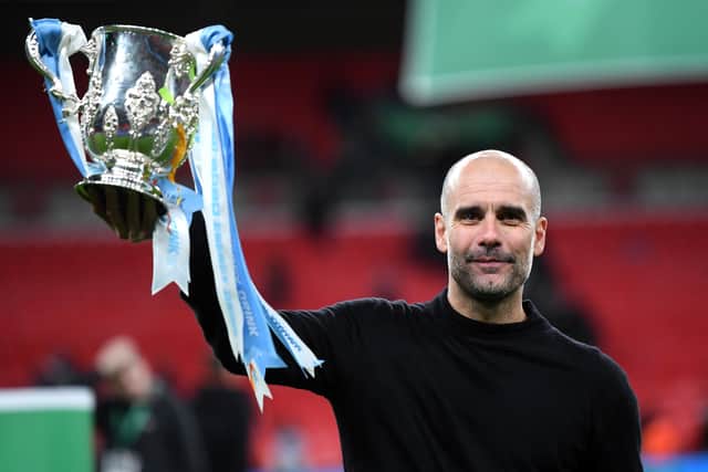 Pep Guardiola, manager of Manchester City , with the 2020 League Cup trophy. Photo by Laurence Griffiths/Getty Images