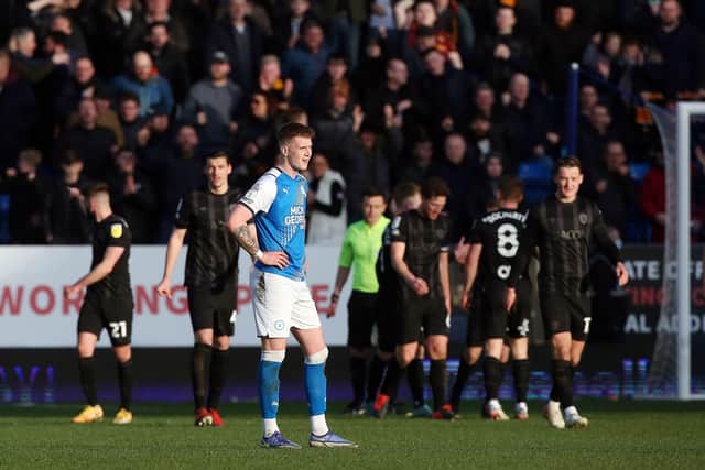 Josh Knight of Peterborough United cuts a dejected figure as Hull City celebrate a goal. Photo: Joe Dent/theposh.com.