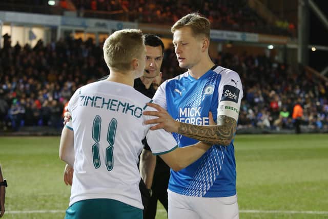 Posh skipper Frankie Kent embraces Manchester City's Oleksandr Zinchenko ahead of kick-off. Photo: Joe Dent/theposhcom.