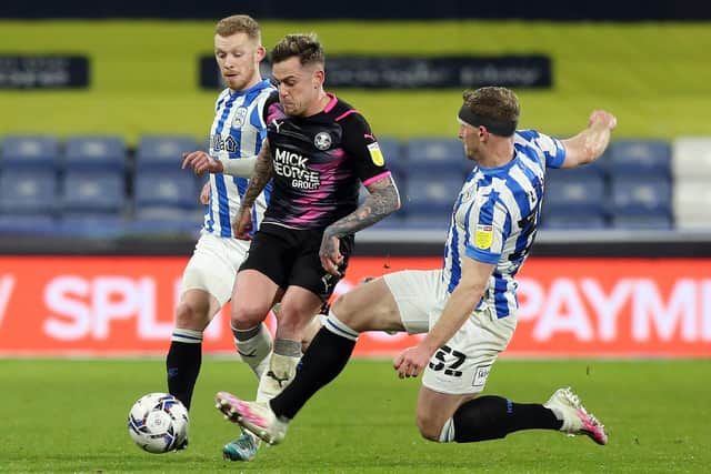 Sammie Szmodics of Peterborough United is put under pressure by Tom Lees and Lewis O'Brien of Huddersfield Town. Photo: Joe Dent/theposh.com.