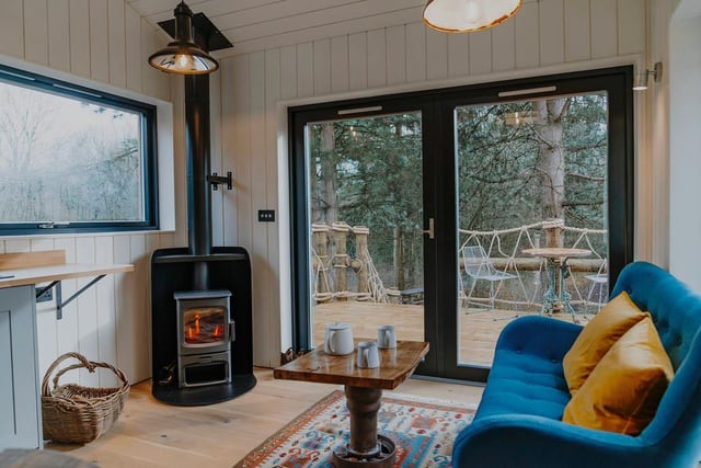 Cosy up in front of the fire in the living room while looking out to the forest.