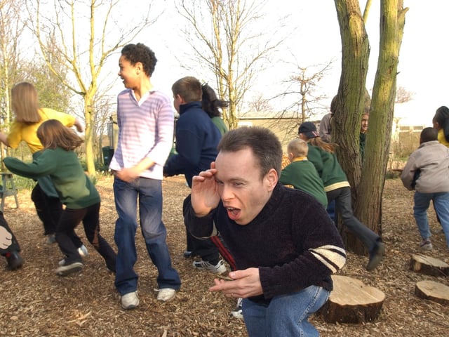 Yaxley based actor Warwick Davies, at the New Ark centre to officially open the new Eco centre (pictured background), plays hide-and -seek in the woodland area with local youngsters.