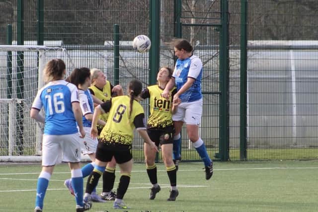 Natalie Hurst of Posh Women outjumps the Leafield Athletic defence. Photo: Gary Reed.