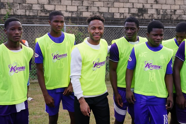 Manchester City's Raheem Sterling (centre) with young footballers in Trenchtown in Kingston, Jamaica, ahead of the arrival of the Duke and Duchess of Cambridge for a game of football, on day four of their tour of the Caribbean on behalf of the Queen to mark her Platinum Jubilee. Picture date: Tuesday March 22, 2022. EMN-220323-131237005