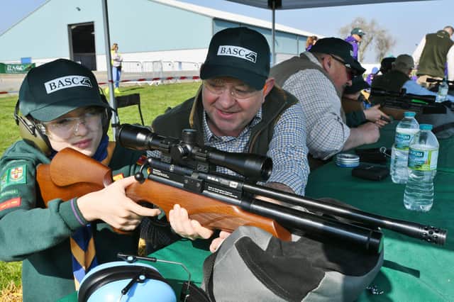 Kids Country Cubs and Scouts event at the East of England Arena. Instructor Ian Richardson with Joshua Perkins learning how to use and air rifle. EMN-220328-140200009
