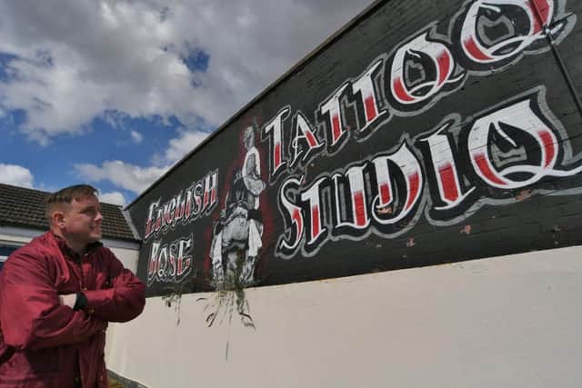 Nathan pictured stood next to his artwork in Lincoln Road.