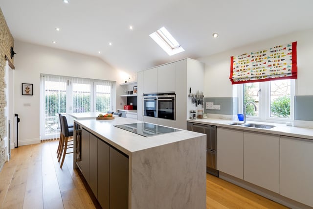 The open-plan kitchen is set to the side of the property and has an integrated island with a breakfast bar for informal dining. There are a number of integrated appliances included.