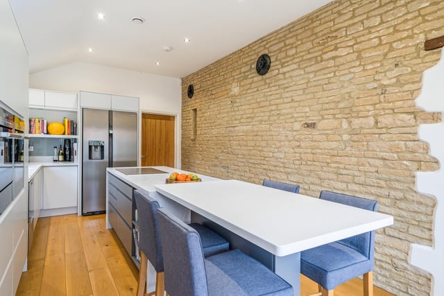 The open-plan kitchen is set to the side of the property and has an integrated island with a breakfast bar for informal dining. There are a number of integrated appliances included.
