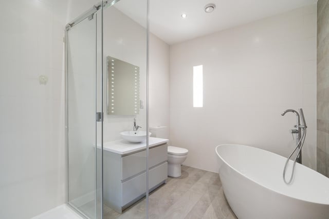 The family bathroom features a striking freestanding bath tub and separate shower.