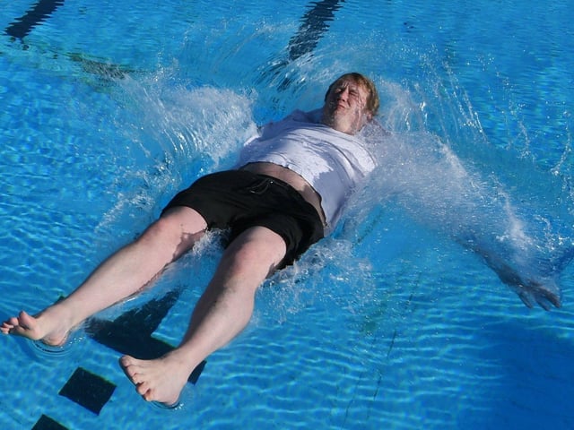 Opening of the Lido - FIRST in the pool this season MP for Peterborough Paul Bristow -  pushed in by Lido opening day ever-present John Peach EMN-220204-104037009