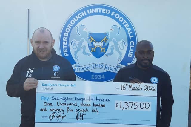 Posh Academy Manager Kieran Scarff and Under 18s Manager Jamal Campbell Ryce with the cheque they presented to Sue Ryder Thorpe Hall Hospice.