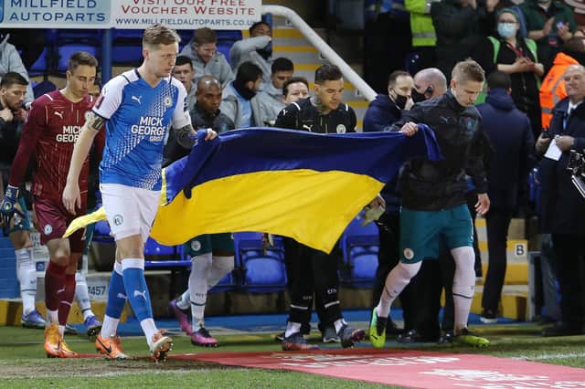 Frankie Kent walks out with the flag supplied by St Olga.