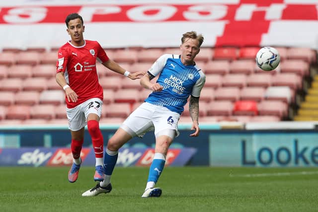 Frankie Kent of Peterborough United in action against Amine Bassi of Barnsley. Photo: Joe Dent/theposh.com.