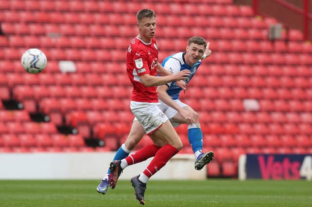 Jack Taylor of Peterborough United in action against Mads Juel Andersen of Barnsley. Photo: Joe Dent/theposh.com.
