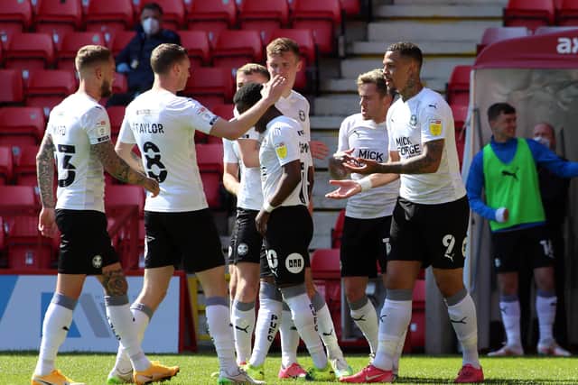 Jonson Clarke-Harris of Peterborough United (9) is congratulated by team-mates after scoring his 29th League One goal of the season at Charlton. Photo: Joe Dent/theposh.com.