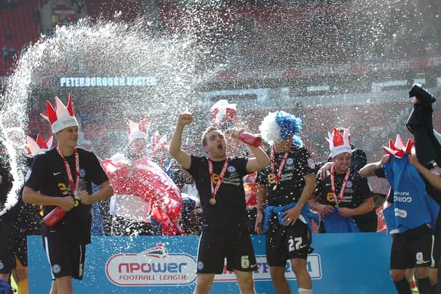 Champagne Charlie Lee leads the Posh celebrations at Old Trafford.