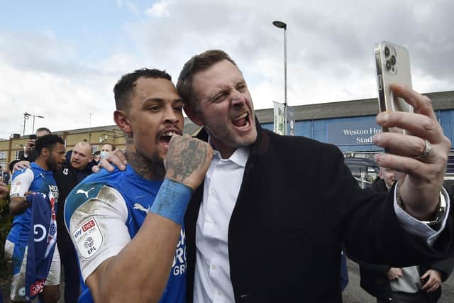 Jonson Clarke celebrates promotion with Posh co-owner Darragh MacAnthony. Photo: David Lowndes.