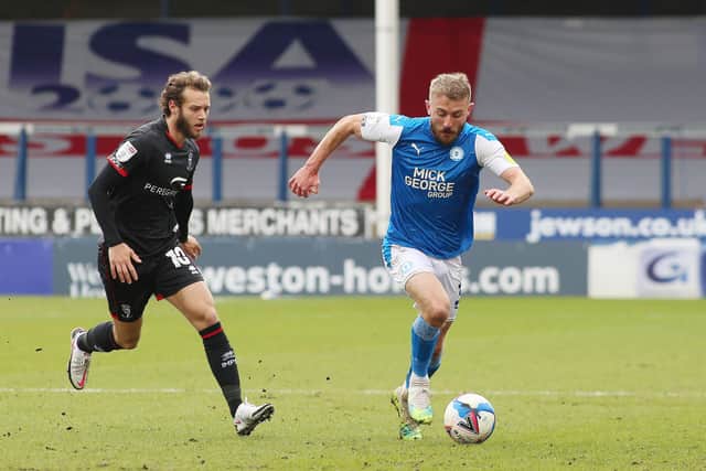 Dan Butler of Peterborough United in action with Jorge Grant of Lincoln City. Photo: Joe Dent/theposh.com.