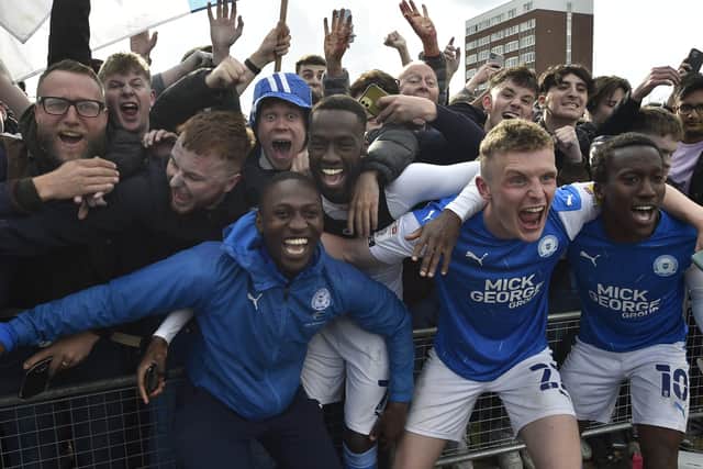 Posh players celebrate promotion with fans outside the Weston Homes Stadium. Photo: David Lowndes.
