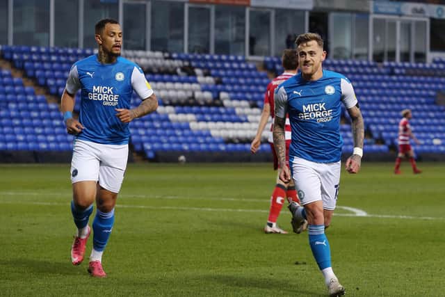 Sammie Szmodics celebrates a goal for Posh with Jonson Clarke-Harris (left).
