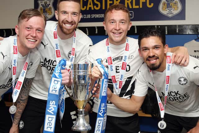 (from left) Frankie Kent, Mark Beevers, Louis Reed and Niall Mason with the League One runners-up trophy and their individual medals.