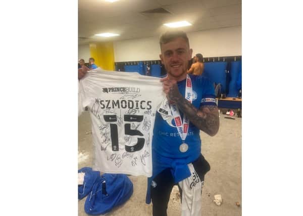 Sammie Szmodics with the signed shirt he is auctioning off.
