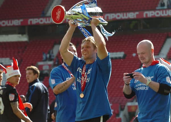 Star Posh striker Craig Mackail-Smith holds aloft the 2011 League One play-off final trophy.